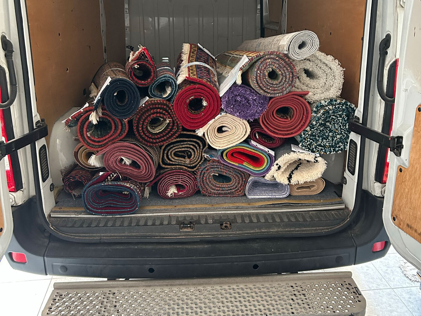 Blick in einen Transporter voller Teppichrollen